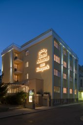 Gebäude-Außenansicht bei Nacht des gelben Gebäudes mit beleuchteter Anschrift